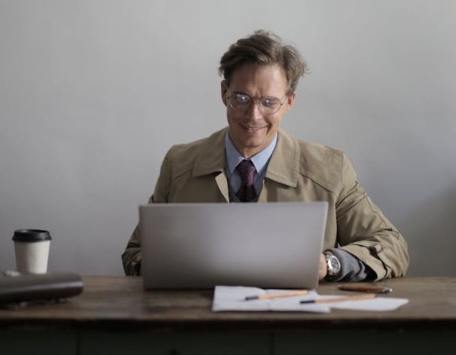 a man typing something on the computer while smiling