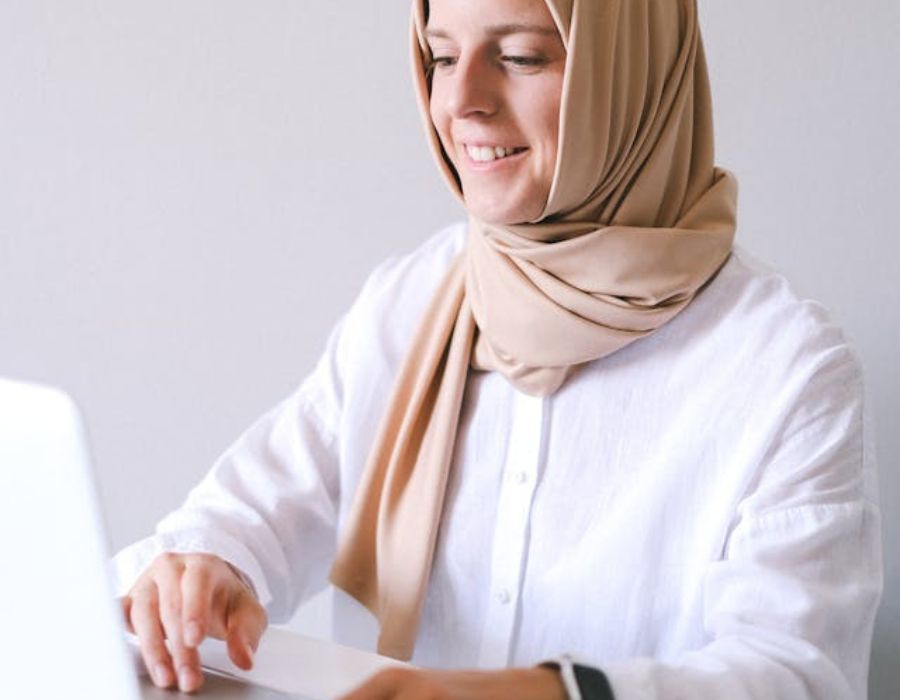 a woman happily using a laptop