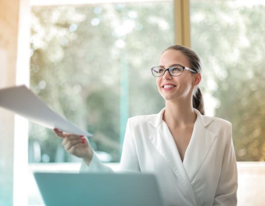 Positive businesswoman doing paperwork in office