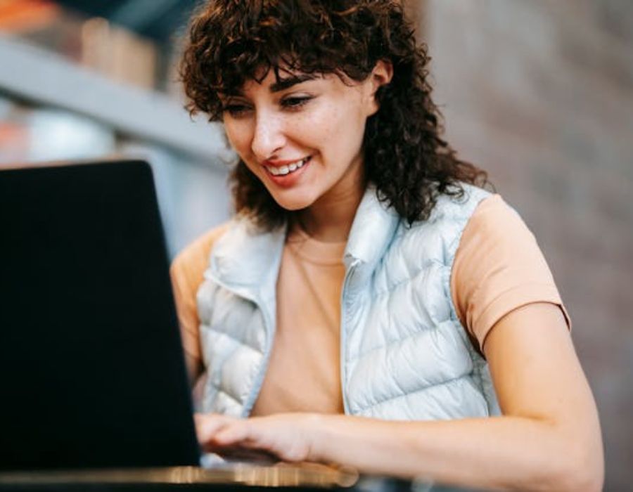 a woman using a laptop while smilling