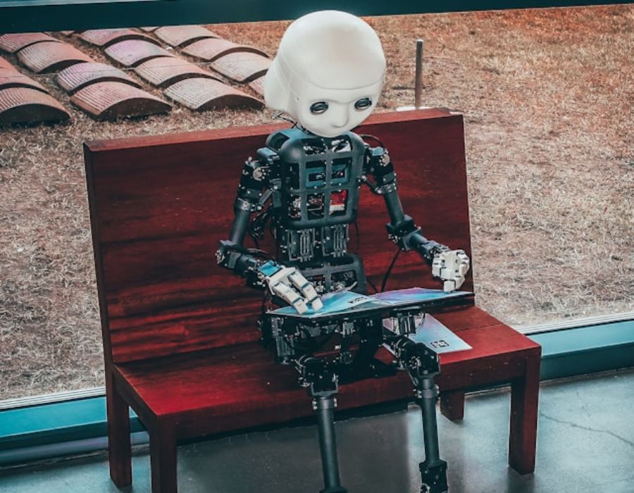 a robot sitting on a bench browsing