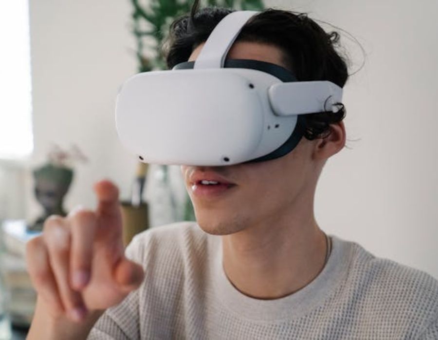 Young male interacting with virtual reality headset in apartment